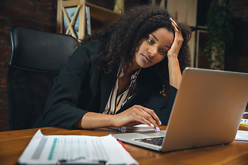 Image showing Young woman working in modern office using devices and gadgets. Making reports, analitycs, routine processing tasks