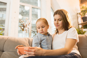 Image showing Family time. Mother and daughter having time together at home, look happy and sincere