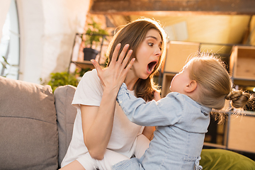 Image showing Family time. Mother and daughter having time together at home, look happy and sincere