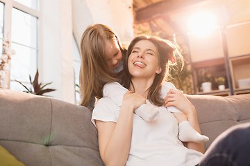 Image showing Family time. Mother and daughter having time together at home, look happy and sincere