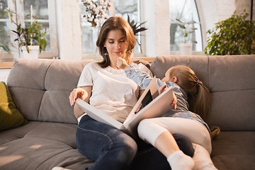 Image showing Family time. Mother and daughter having time together at home, look happy and sincere