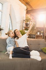 Image showing Family time. Mother and daughter having time together at home, look happy and sincere