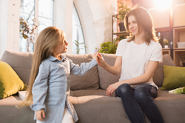 Image showing Family time. Mother and daughter having time together at home, look happy and sincere