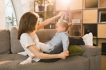 Image showing Family time. Mother and daughter having time together at home, look happy and sincere