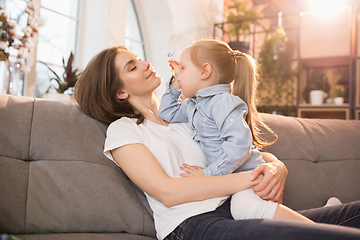 Image showing Family time. Mother and daughter having time together at home, look happy and sincere