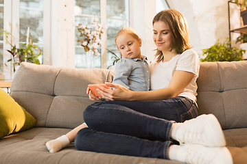 Image showing Family time. Mother and daughter having time together at home, look happy and sincere