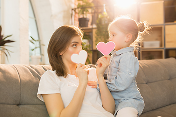 Image showing Family time. Mother and daughter having time together at home, look happy and sincere