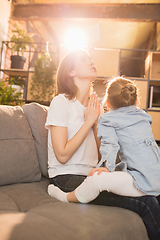 Image showing Family time. Mother and daughter having time together at home, look happy and sincere