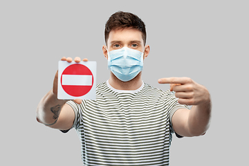 Image showing young man girl in medical mask showing stop sign