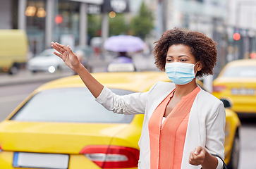 Image showing african woman in face mask catching taxi in city