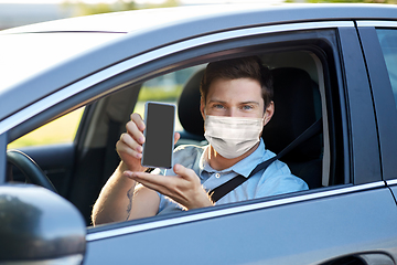 Image showing male car driver with smartphone wearing face mask