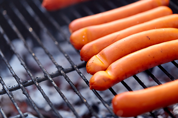 Image showing meat sausages roasting on hot brazier grill