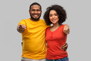 Image showing happy african american couple pointing to camera