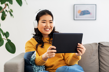 Image showing asian woman with headphones and tablet pc at home