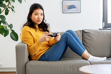 Image showing asian woman with gamepad playing game at home