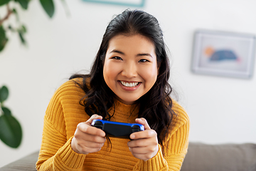 Image showing asian woman with gamepad playing game at home