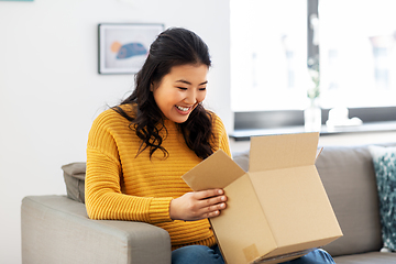 Image showing happy asian young woman with parcel box at home