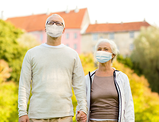 Image showing senior couple in protective medical masks outdoors