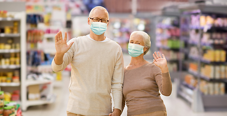 Image showing senior couple in medical masks at supermarket