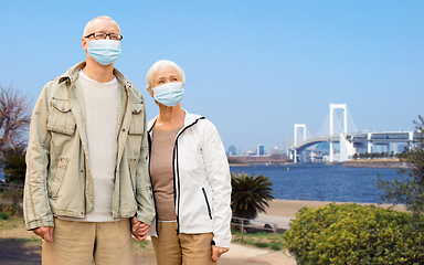 Image showing senior couple in protective medical masks in japan