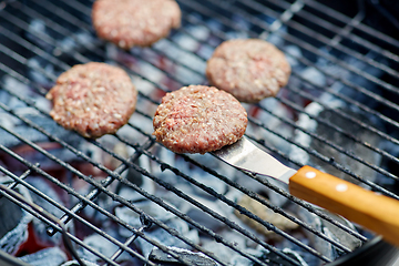 Image showing close up of meat cutlets roasting on grill