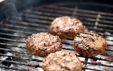 Image showing close up of meat cutlets roasting on grill