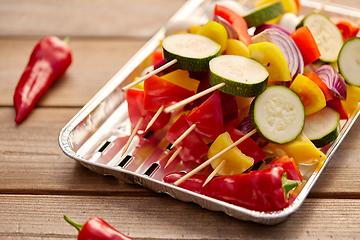 Image showing close up of vegetables on skewers on foil grill