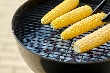 Image showing close up of corn roasting on grill outdoors