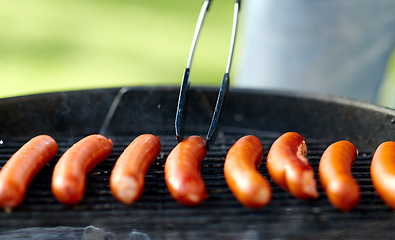 Image showing meat sausages roasting on hot brazier grill