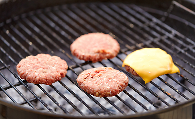 Image showing meat cutlet with cheese roasting on barbecue grill