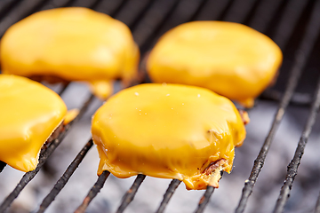 Image showing close up of meat cutlet with cheese on grill