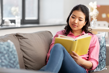 Image showing asian young woman reading book at home