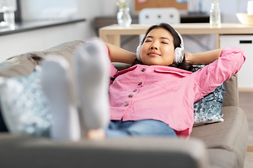 Image showing woman in headphones listening to music at home