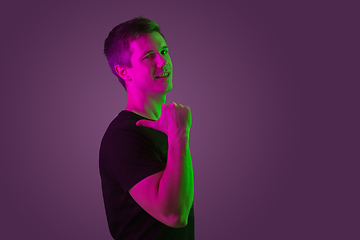 Image showing Caucasian man\'s portrait isolated on purple studio background in neon light