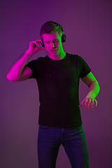 Image showing Caucasian man\'s portrait isolated on purple studio background in neon light