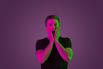 Image showing Caucasian man\'s portrait isolated on purple studio background in neon light