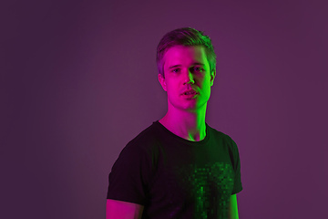 Image showing Caucasian man\'s portrait isolated on purple studio background in neon light