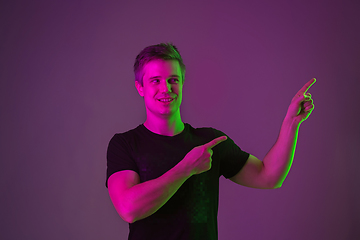 Image showing Caucasian man\'s portrait isolated on purple studio background in neon light