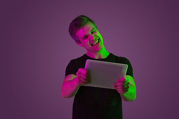 Image showing Caucasian man\'s portrait isolated on purple studio background in neon light