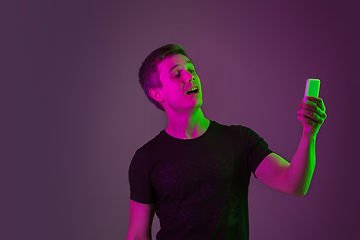 Image showing Caucasian man\'s portrait isolated on purple studio background in neon light