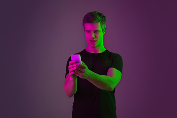 Image showing Caucasian man\'s portrait isolated on purple studio background in neon light