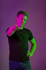 Image showing Caucasian man\'s portrait isolated on purple studio background in neon light