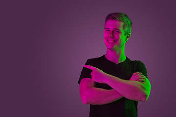 Image showing Caucasian man\'s portrait isolated on purple studio background in neon light