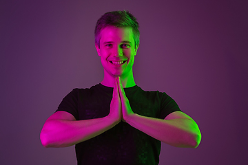 Image showing Caucasian man\'s portrait isolated on purple studio background in neon light