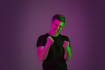 Image showing Caucasian man\'s portrait isolated on purple studio background in neon light