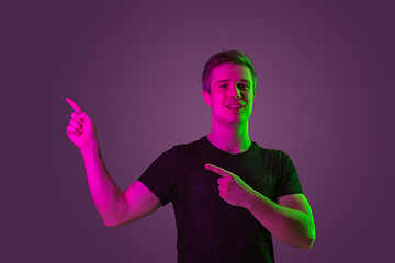 Image showing Caucasian man\'s portrait isolated on purple studio background in neon light