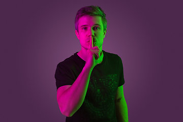 Image showing Caucasian man\'s portrait isolated on purple studio background in neon light