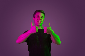 Image showing Caucasian man\'s portrait isolated on purple studio background in neon light