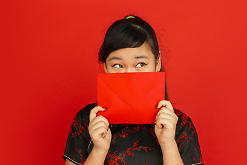 Image showing Happy Chinese new year. Asian young girls\'s portrait isolated on red background