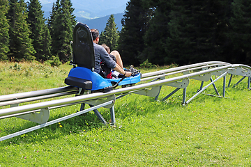 Image showing Father and son enjoying a summer fun roller alpine coaster ride